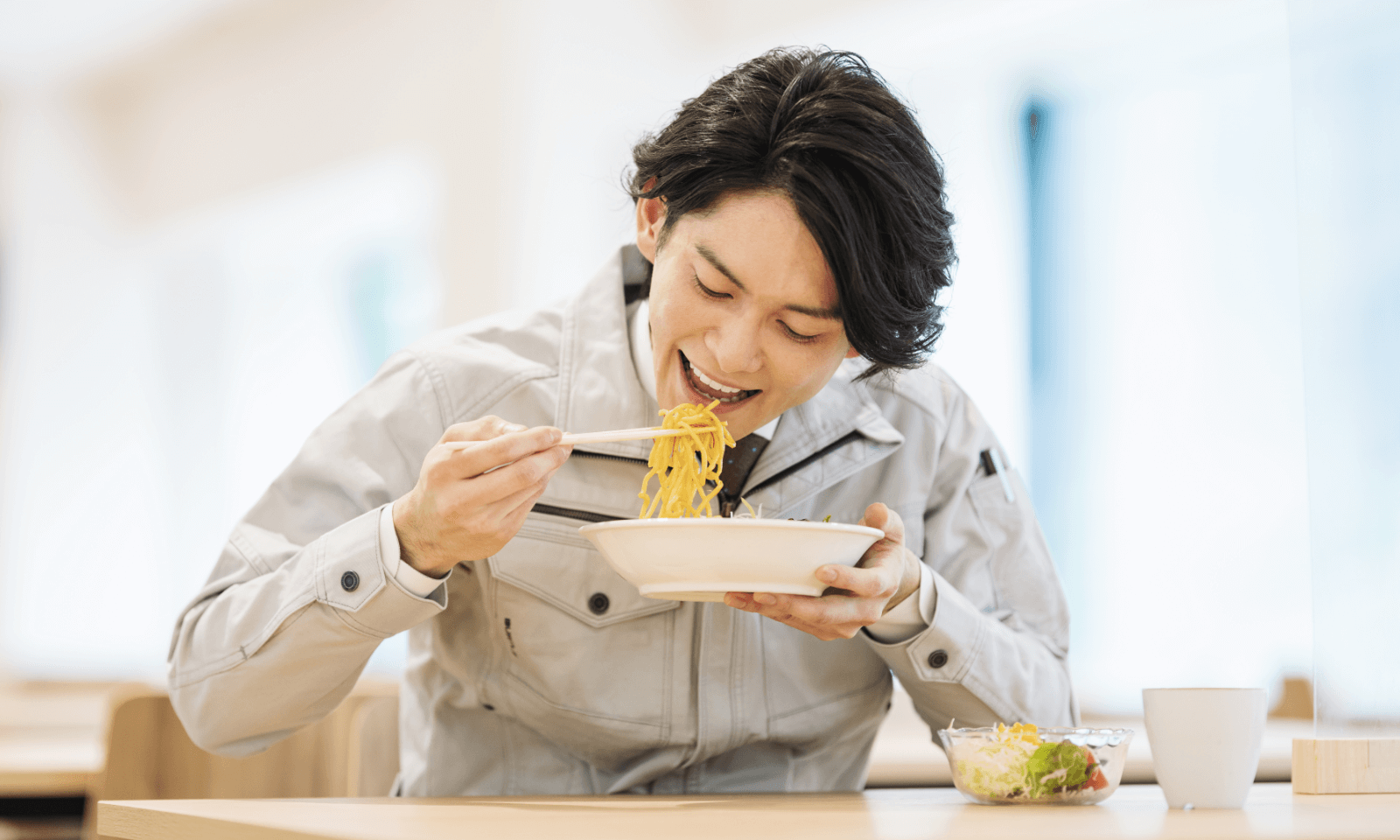 おいしいラーメンを食べている男性スタッフ
